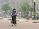 A cyclist wears a mask due to poor air quality as smoke from wildfires in Ontario and Quebec hangs over Ottawa on June 6. Fires throughout the country continued all summer long.