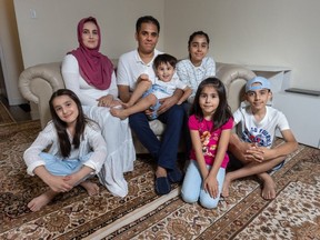 The Rahimi family (FROM LEFT TO RIGHT) Zahara (DAUGHTER), Farida (MOTHER) Omar (SON BEING HELD) by Ahmad Rahimi (FATHER), Marwa (DAUGHTER), Iqra (DAUGHTER) and Ahmad Fakher (SON) at their Mississauga home, who escaped the Taliban in Afghanistan where he was a security head for Canada’s embassy in Kabul.