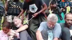 The Abu Sayyaf terrorist group released a video Tuesday demanding more than $100-million for the release of four hostages, including two Canadians, who were kidnapped from a resort in the southern Philippines in September. The 90-second video obtained by the SITE Intelligence Group showed black-clad gunmen standing over Canadians John Ridsdel and Robert Hall, as well Hall's girlfriend Marites Flor and Norwegian Kjartan Sekkingstad.