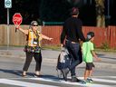 A crossing guard helps a parent walk a child to school in Ottawa for the first time this year. Temperatures in Ottawa and West Quebec continue to soar.