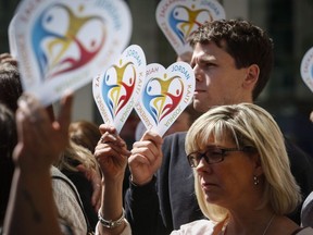 Family members of the five slain students hold heart signs with their names on them following a court decision in Calgary