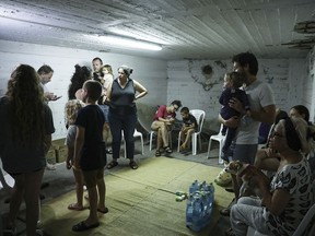 Israelis take cover in a shelter as a siren sounds a warning