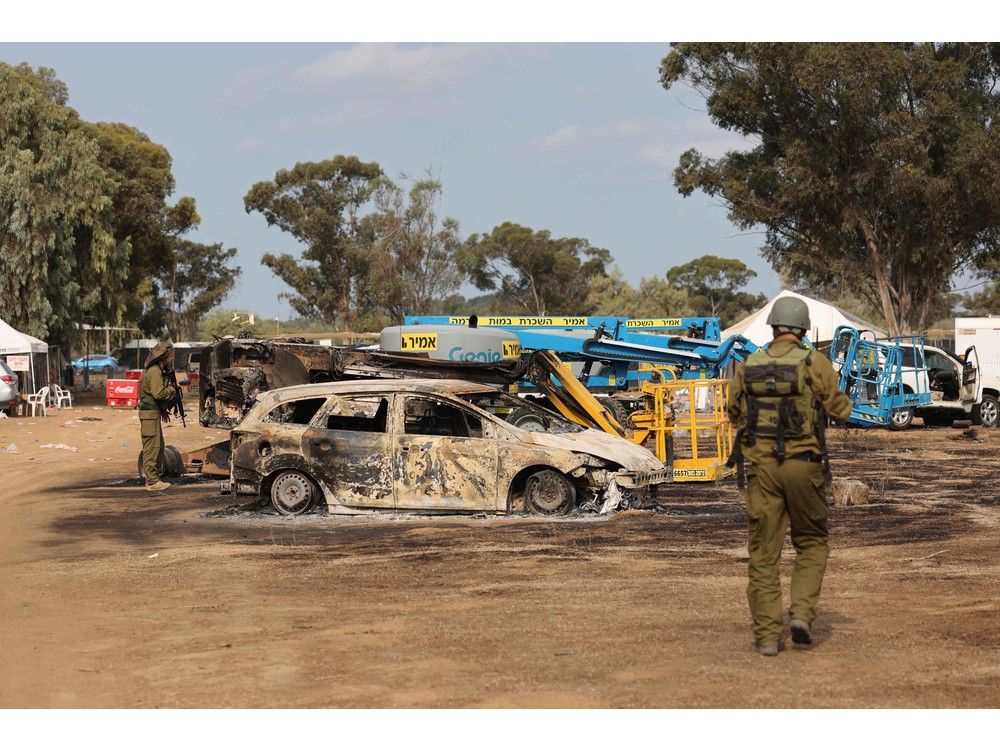 Israeli troops inspect the ravaged site of the weekend attack on the Supernova desert music festival near Kibbutz Reim in the Negev desert. 