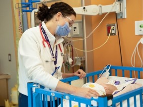 Dr. Ericka Bariciak, a neonatal specialist at TOH and CHEO, was part of a team that began preparations to evacuate babies from the NICU soon after they were informed of the fire. Bariciak attends to a baby at CHEO on Sunday. Handout, CHEO