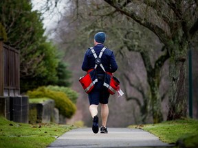 A Canada Post letter carrier delivers mail by foot to houses in Vancouver. One taxpayer, who is also a mail carrier, claimed he didn't receive the CRA's correspondence.