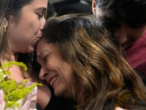 A mother, center, hugs her children at the airport after arriving on a flight from Tel Aviv, Israel, in Brasilia, Brazil, Wednesday, Oct. 11, 2023, following the war between Israel and the terrorist group Hamas.