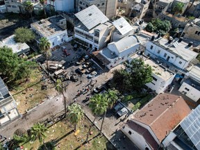 This aerial view shows people walking at the site of the al-Ahli hospital in central Gaza on October 18, 2023 in the aftermath of an overnight explosion.