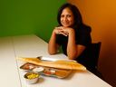 Sundari Mohanram poses for a photo at her restaurant Sundari's Kitchen in Ottawa. Mohanram sits with an order of a ghee masala dosa and masala on the side.