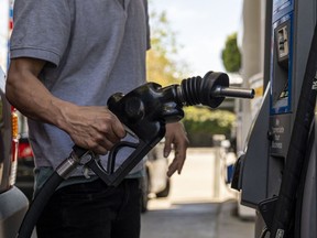 A driver returns a fuel nozzle to a gas pump