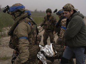 Ukrainian servicemen evacuate injured comrade