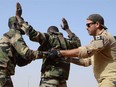 Canadian Special Operations Regiment instructor teaches soldiers from the Niger Army how to properly search a detainee in Agadez, Niger, Feb. 24, 2014 during that year's Flintlock exercise.