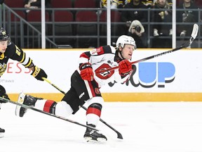 Brady Stonehouse of the Ottawa 67’s pulls away from the checking of Sarnia's Nathan Omeri to get a shot off during Sunday's game at TD Place.