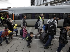 Policemen and a group of migrants stand on the platform at the Swedish end of the bridge between Sweden and Denmark in Malmo, Sweden, in 2015.