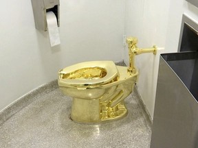 FILE: This Sept. 16, 2016 file image made from a video shows the 18-karat toilet, titled "America," by Maurizio Cattelan in the restroom of the Solomon R. Guggenheim Museum in New York.