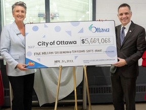OLG senior manager of municipal relations Kathleen Devine and Mayor Mark Sutcliffe pose for a novelty cheque photo-op.