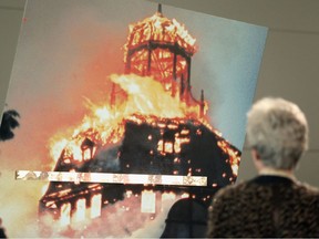 A visitor looks at a photo of a synagogue burning during the 1938 Kristallnacht pogroms at an exhibit at the Topography of Terror museum in Berlin, Germany.