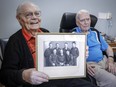 Royal Canadian Air Force veteran Bill Cook, left, holds a Second World War photo of his Halifax bomber crew members, as fellow veteran Hank Jackman, 103, looks on in Calgary, Tuesday, Nov. 7, 2023.