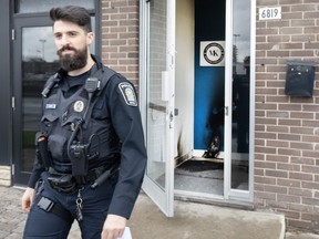 A police officer leaves from the entrance of a Jewish community centre Monday, Nov. 27, 2023, in Montreal. Montreal police are investigating after an incendiary object was allegedly thrown against the door of a Jewish community centre.