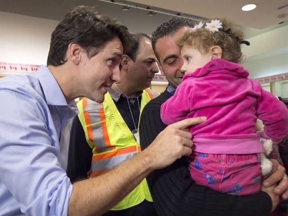 The Liberals originally came to power partly because of the humanitarian spirit they displayed in promising to take in so many Syrian refugees in 2015.  Here, Prime Minister Justin Trudeau greets 16-month-old Madeleine Jamkossian, and her father at Pearson International airport, on Dec. 11, 2015.