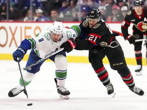 Ottawa Senators right winger Mathieu Joseph tries to push Vancouver Canucks centre J.T. Miller.