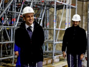French President Emmanuel Macron (L) walks inside the nave during a visit of the reconstruction work at the Notre-Dame de Paris Cathedral