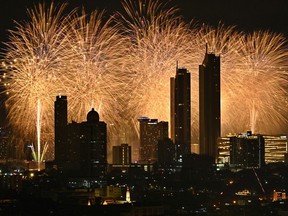 Fireworks explode over a city skyline during New Year's Eve celebrations in Bangkok