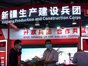 Staff members stand at a booth for the Xinjiang Production and Construction Corps, a state-run authority that handles administrative, economic, and paramilitary functions in parts of western China's Xinjiang Uyghur Autonomous Region, at the China International Fair for Trade in Services in Beijing, Sept. 3, 2021.