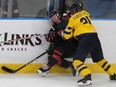 Sweden's Zeb Forsfjall (21) pushes Canada's Owen Beck (8) into the boards during third period preliminary round hockey action at the IIHF World Junior Hockey Championship in Gothenburg, Sweden on Friday, Dec. 29, 2023. There was no penalty called on the play.