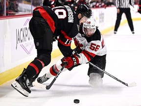 New Jersey Devils left wing Erik Haula forces the puck from Ottawa Senators right wing Drake Batherson