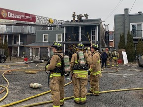 Firefighters work at the scene of a fire on St. Patrick Street on Monday, Dec. 25, 2023.