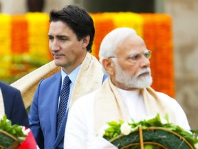 Justin Trudeau walks past Narendra Modi