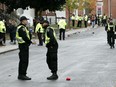 Dozens of uniformed police officers line the streets of University District in Kingston on Saturday, Oct. 21, 2023, as Queen's University Homecoming weekend spilled into the streets.