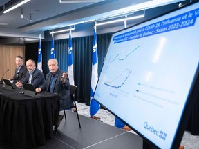 Quebec's Health Minister Christian Dube, centre, and doctors Luc Boileau, right, and Gilbert Boucher, left, update the vaccination and emergency room situation during a press briefing Tuesday, December 19, 2023 in Montreal.