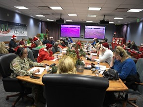This image provided by the Department of Defense shows volunteers answering phones and emails from children around the globe during the annual NORAD Tracks Santa event