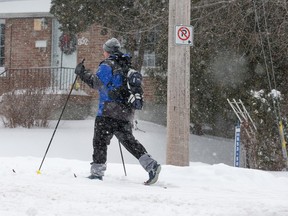 Man on skis on unplowed sidewalk