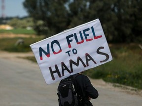 A protester holds a sign during a demonstration against the humanitarian aid that enters into the Gaza Strip on January 29, 2024 in Kerem Shalom Crossing Point, Israel.