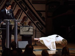 Prime Minister Justin Trudeau looks on as his wife Sophie Gregoire Trudeau performs a yoga pose as they joke on stage during the annual Press Gallery Dinner at the Canadian Museum of History, June 2016 in Gatineau.