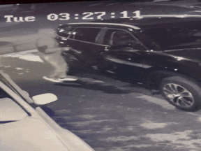 A clip from a home security camera shows one of two vandals breaking the car's windows.