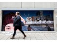 Pedestrian walks by uOttawa sign