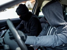 Car thieves in hoodies, behind the wheel