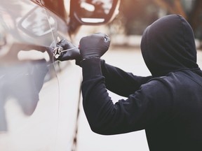 Hooded man breaking in to a car