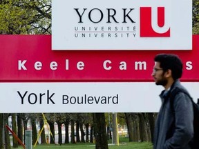 A student walks past a sign at the Keele campus of York University in Toronto on April 12, 2012.