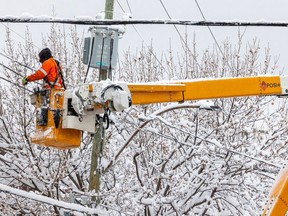 A Hydro crew works to restore power on Charlevoix St. in the Pointe-St-Charles district after a major snowfall in Montreal Monday Dec. 4, 2023.