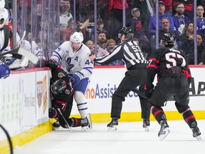 Morgan Rielly #44 of the Toronto Maple Leafs stands over Ridly Greig