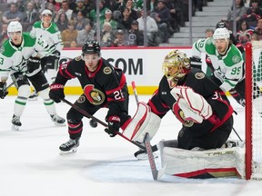 Senators netminder Anton Forsberg tracks the puck with defenceman Erik Brannstrom at his side during the first period of Thursday's game against the Stars.