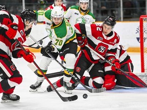 Matthew Mayich (22) of the Ottawa 67's and others battle for possession of the puck in front of the Ottawa net during a game against the London Knights at the Arena at TD Place on Feb. 24, 2024.