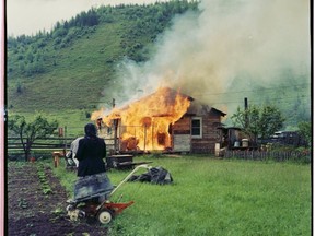 A Sons of Freedom Doukhobor woman watches a house burn