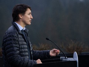 Prime Minister Justin Trudeau speaks in the rain during a news conference on housing in Vancouver on Feb. 20, 2024.