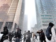 Pedestrians in Toronto's financial district on a snowy day. Over one million immigrants have arrived in Canada over a one-year period to July 1, 2023.