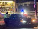 An Ottawa Police Service officer inspects a vehicle at the scene on St. Joseph Boulevard on Saturday night.